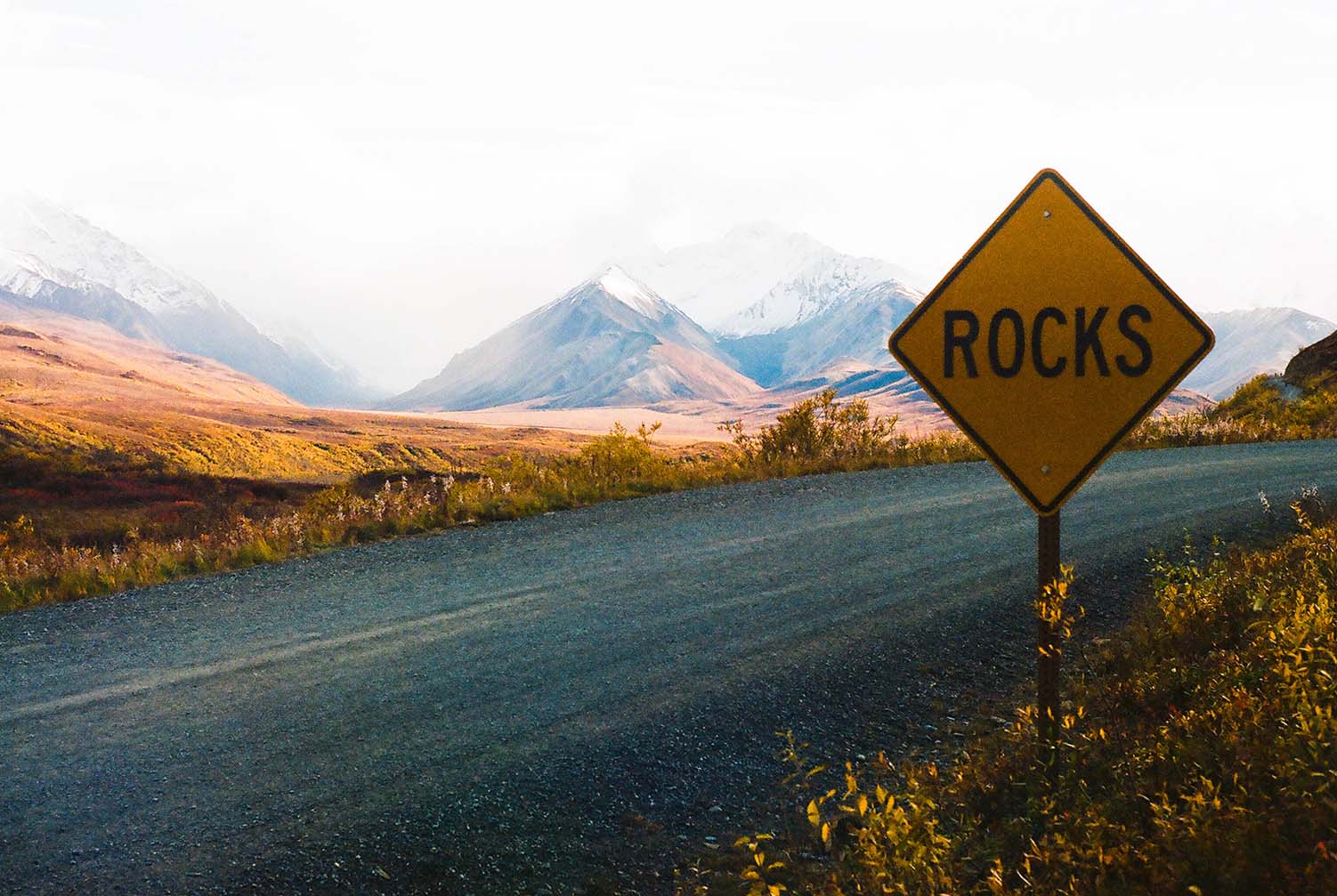 Sign for rocks and road with mountains in background in Denali, Alaska