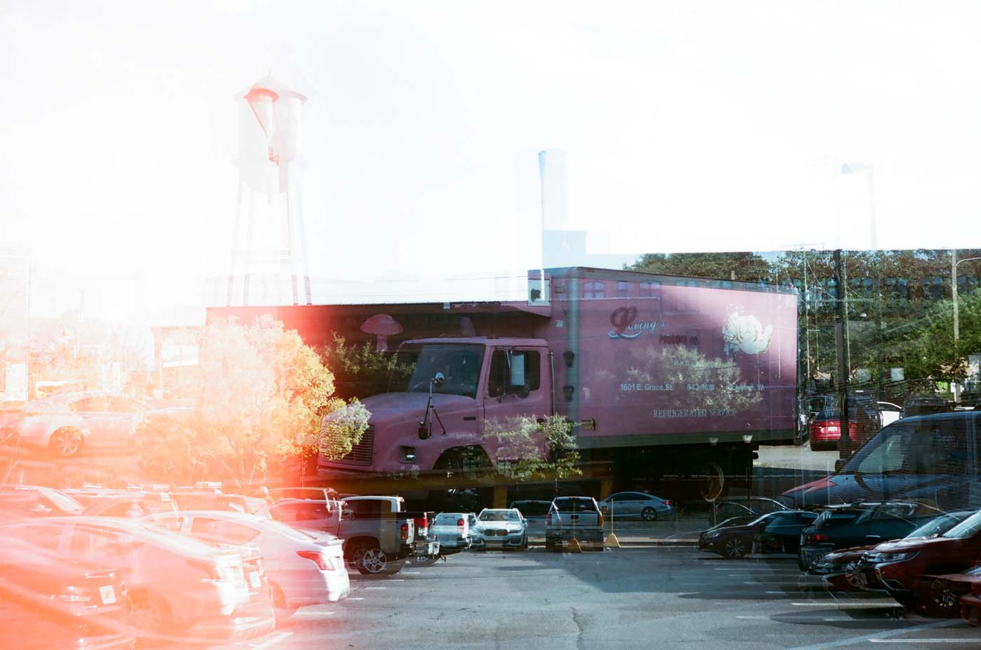 Double exposure and light leak in a car park, pink truck