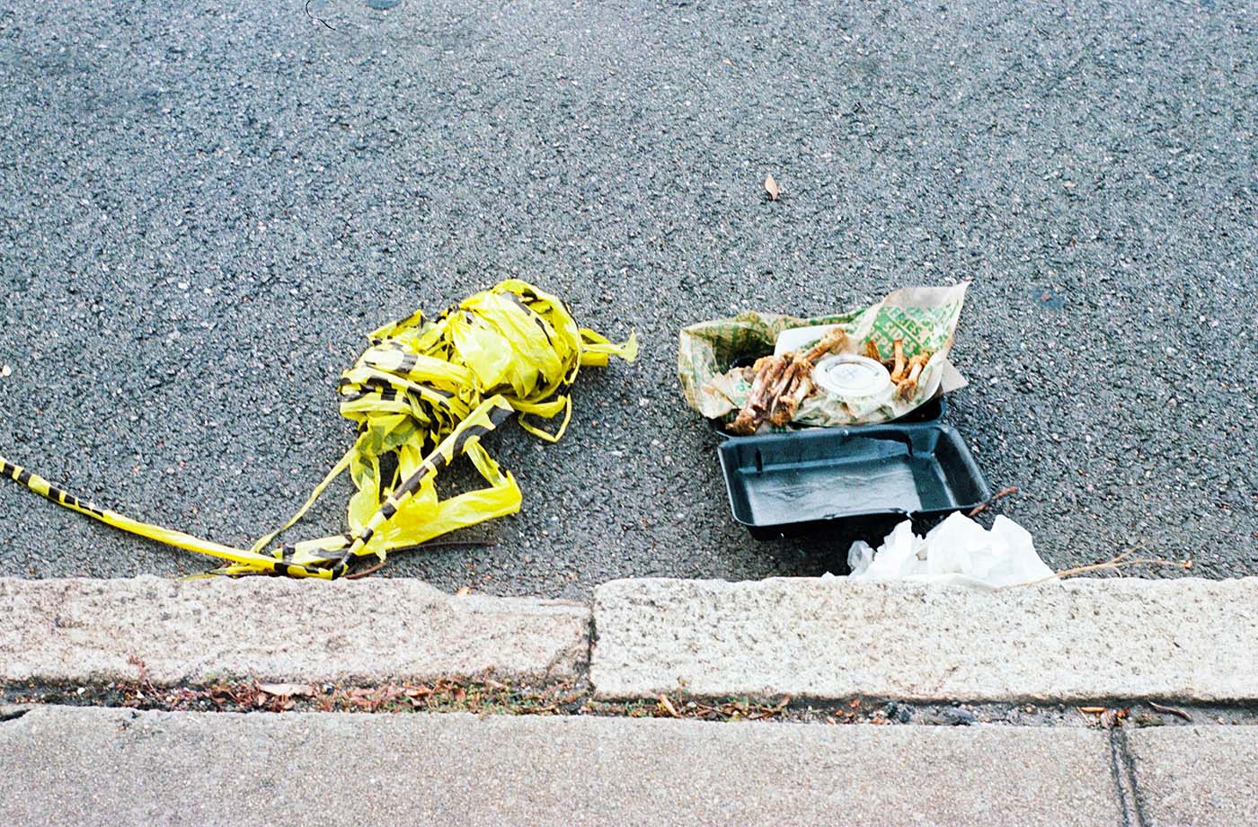 Box with bones and leftovers on the asphalt next to police barricade tape