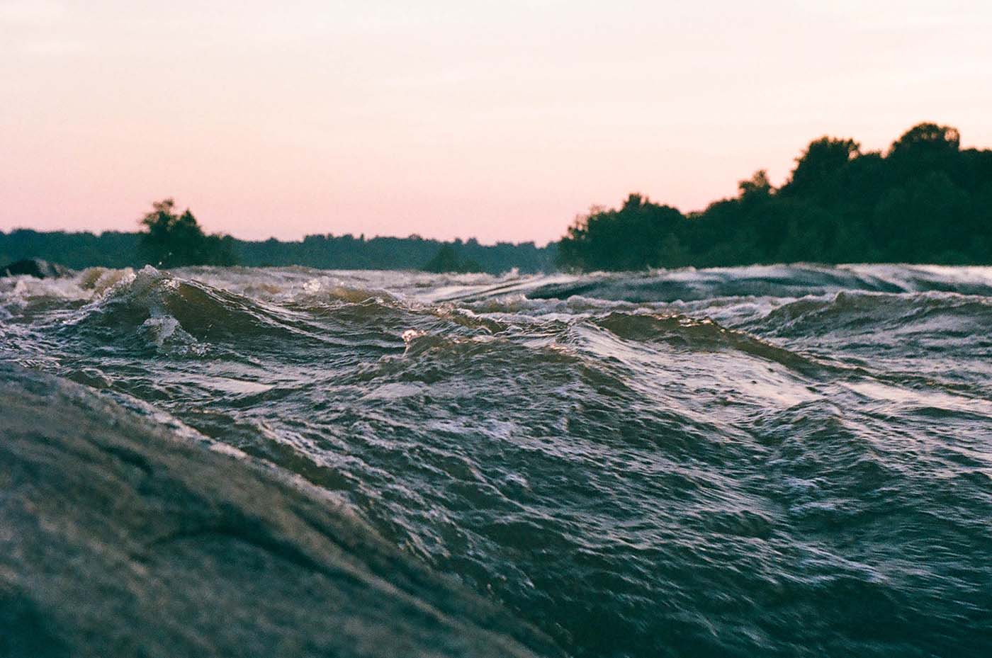 River with white water in the evening from close up