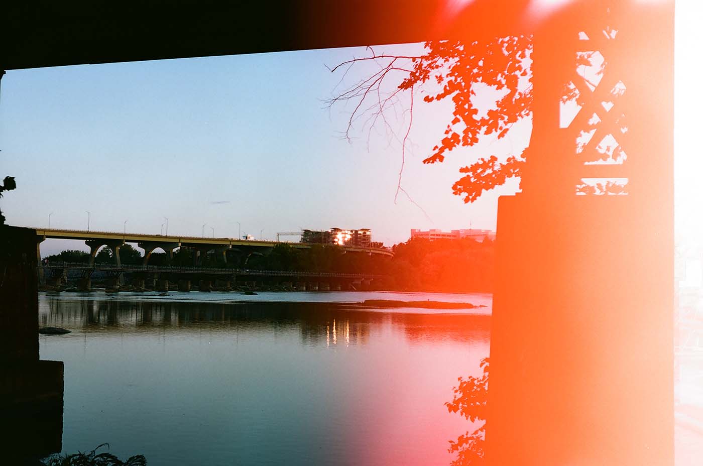 River and bridge, dramatic light leak on film photograph