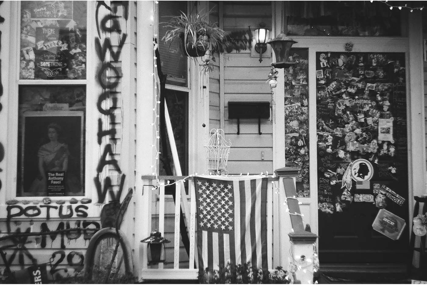 House covered in graffiti, stickers, USA flag, paniting of Queen Elisabeth II