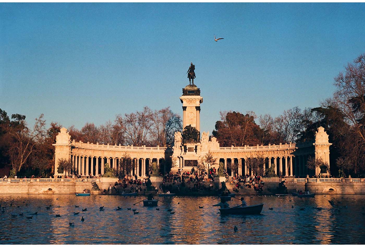 People resting by a monument in El Retiro park in Madrid