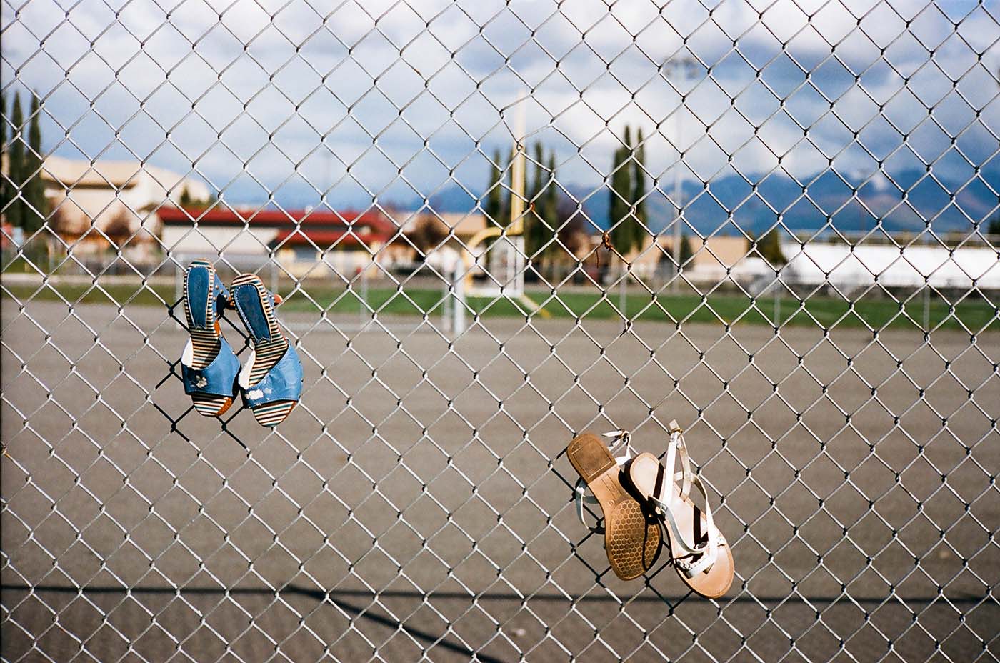 Shoes hanging from a fence in a soccer field